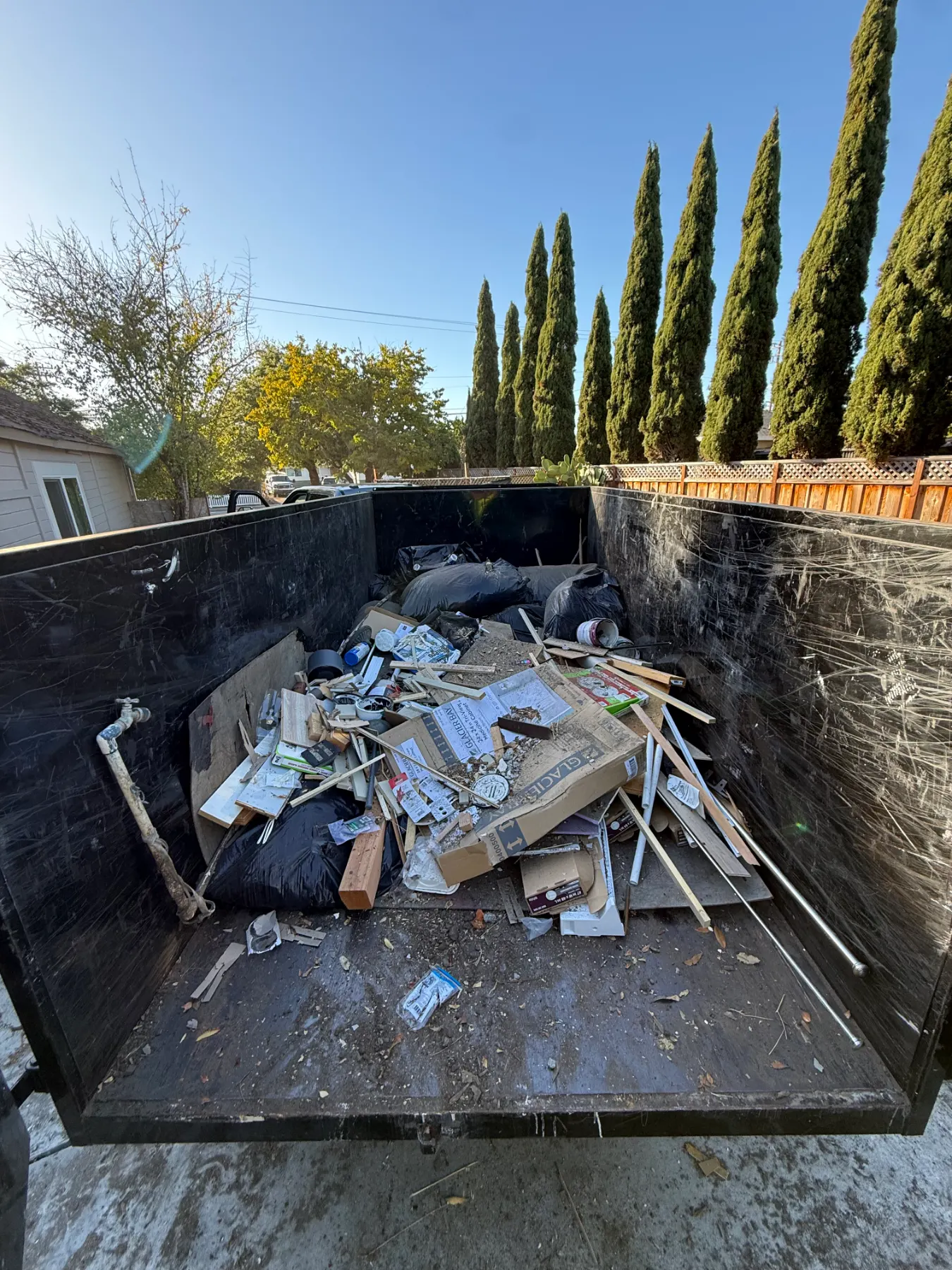 Dump trailer loaded with construction debris and bagged junk