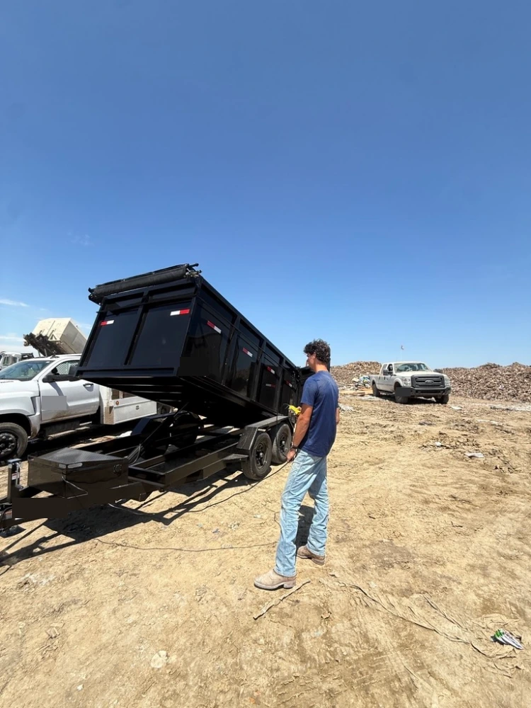 Crew member unloading the dump trailer at the dump